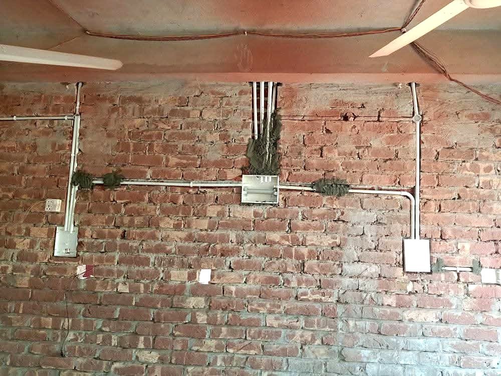 দেয়ালে কন্ডুইট পাইপ ও সুইচ বোর্ড বসানো